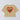Beige cropped t-shirt with red heart and green palm tree graphic and "ciao" text on back.